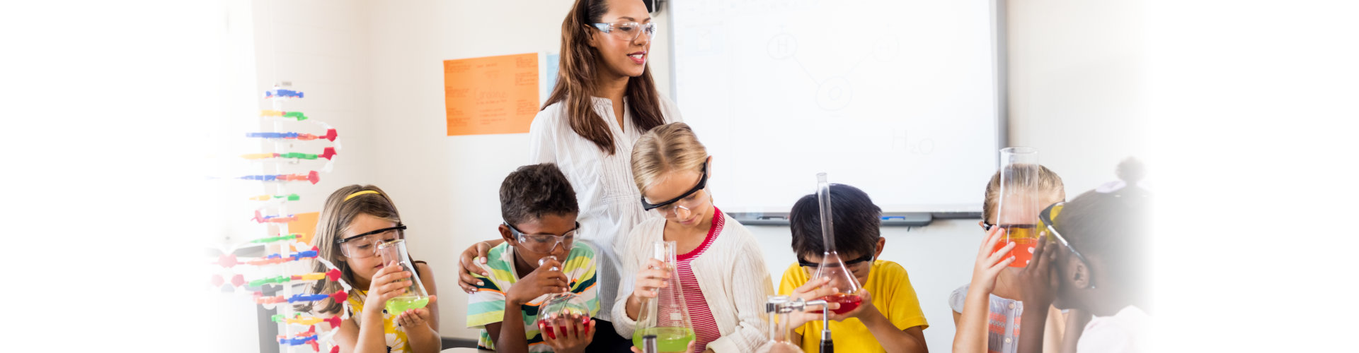 children and teacher having fun on science experiments